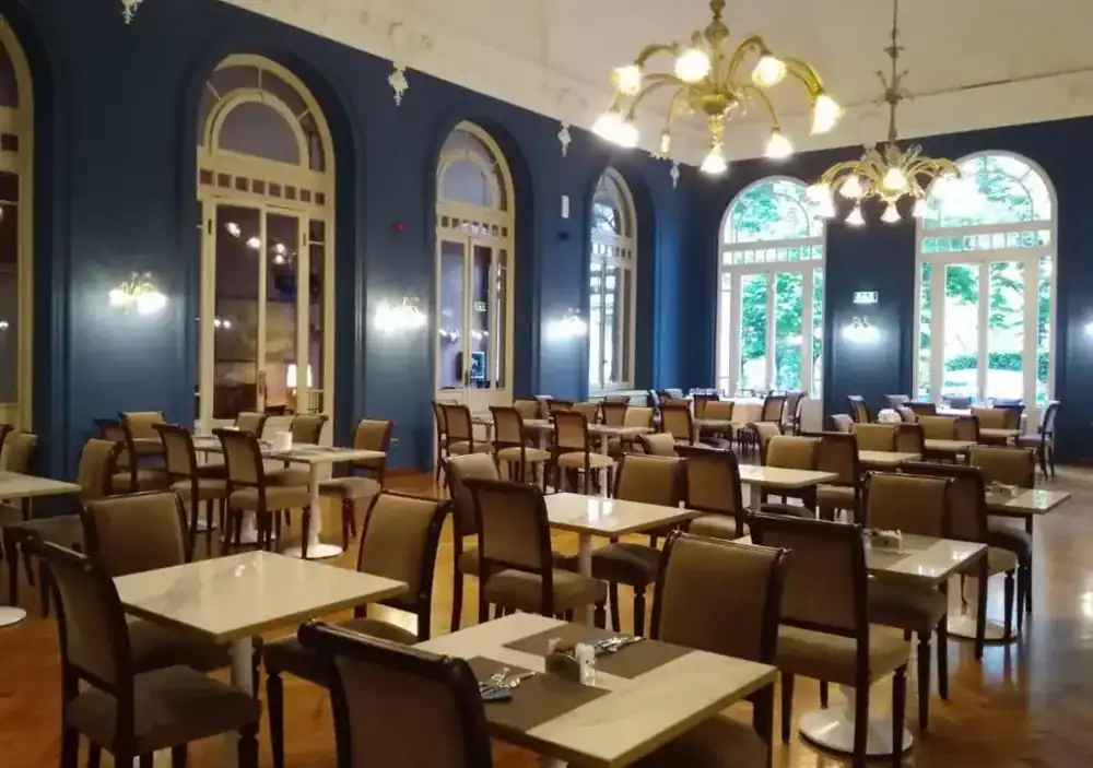 Sala del ristorante con boiserie blu e lampadari in vetro di Murano